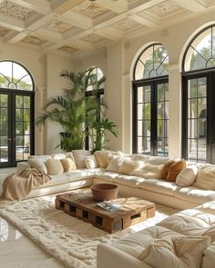 a living room filled with lots of white furniture and large arched windows on the wall