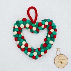 an ornament shaped like a heart with red, white and green beads