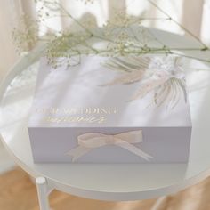 a white box with a bow on it sitting on top of a table