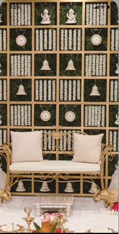 a couch sitting in front of a wall covered with lots of plaques and bells on it