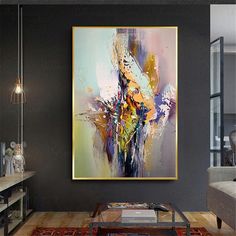 an abstract painting hangs on the wall above a coffee table in a modern living room