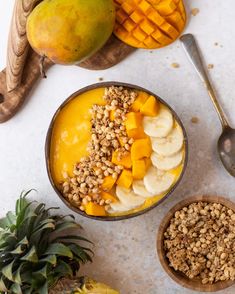 two bowls filled with fruit and granola next to pineapples