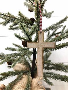 a cross hanging from the side of a christmas tree