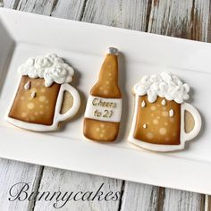 three decorated cookies in the shape of beer mugs on a white platter with text