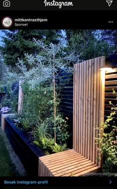 a wooden bench sitting in the middle of a garden next to a tall planter