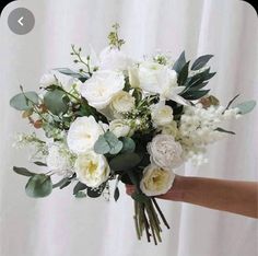 a person holding a bouquet of white flowers