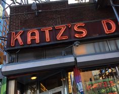 a neon sign that reads katz's diner on the side of a storefront