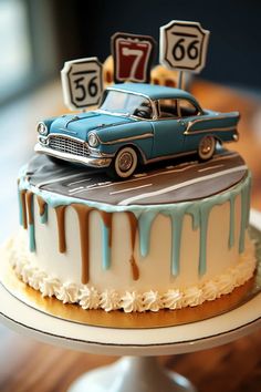 a blue car is on top of a cake with white frosting and brown icing