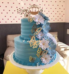 there is a blue cake with flowers on the top and a crown on top that has been decorated