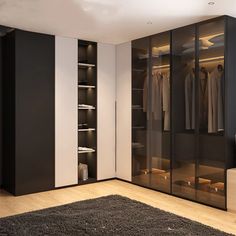 a bedroom with black and white closets, carpeted flooring and wooden floors