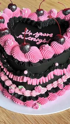 a heart shaped cake with pink and black frosting