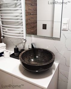 a black bowl sink sitting on top of a white counter