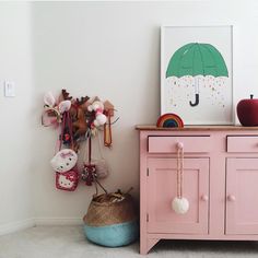 a pink cabinet with an umbrella on it next to a stuffed animal and other items