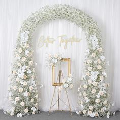 an arch with flowers and greenery on the side is decorated for a wedding ceremony