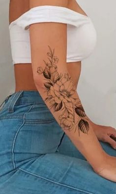 a woman with a flower tattoo on her left arm and back half - sleeved