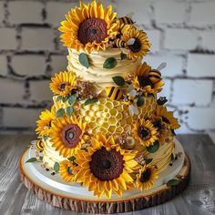 a three tiered cake decorated with sunflowers and bees