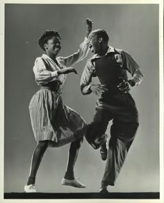 an old black and white photo of two people dancing