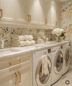 a washer and dryer in a room with flowers on the counter top next to each other