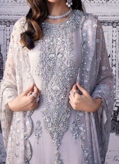 Product Description:  Long shirt in monochrome with a tasteful combination of silver and grey. The outfit features handmade, embroidered straight pants and our characteristic scallop dupatta in a modern twist. Fabric: Chiffon Color: Grey Can be customized in any color Includes:  Shirt Pants Duppata Designer Silver Salwar Kameez With Resham Embroidery, Silver Salwar Kameez With Resham Embroidery, Silver Designer Salwar Kameez For Eid, Silver Embellished Sets For Eid, Embellished Silver Sets For Eid, Elegant Gray Designer Wear Sets, Silver Salwar Kameez With Resham Embroidery For Eid, Silver Resham Embroidered Salwar Kameez For Eid, Silver Semi-stitched Salwar Kameez For Eid