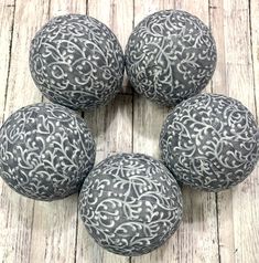 four black and white balls sitting on top of a wooden floor