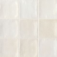 a white tiled wall with several squares in it