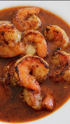 a white plate topped with shrimp and sauce