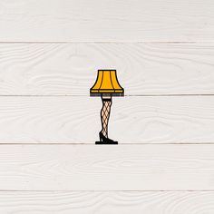 a lamp that is sitting on top of a wooden floor next to a white wall