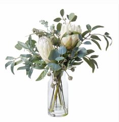 a vase filled with white flowers and greenery