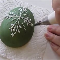 someone is painting an easter egg with white paint