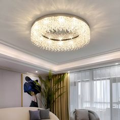 a living room filled with furniture and a chandelier hanging from the ceiling above it