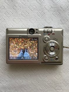 a digital camera sitting on top of a white blanket