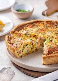 a quiche on a plate with one slice missing