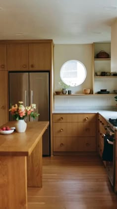 a kitchen with wooden cabinets and an island in front of the stove top is filled with flowers