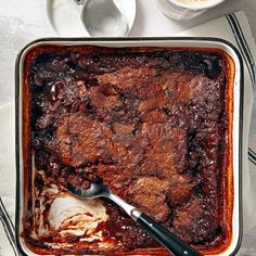 a casserole dish with meat and ice cream in it on a white table