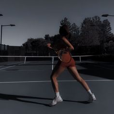 a woman holding a tennis racquet on top of a tennis court