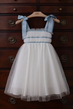 a dress hanging on a wooden dresser in front of a drawer with drawers and drawers