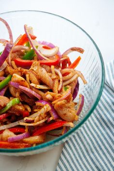 a glass bowl filled with meat and vegetables