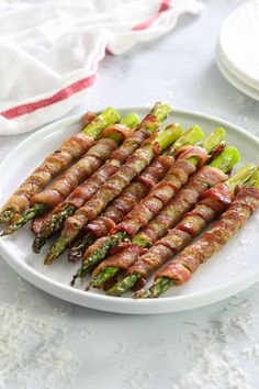 asparagus wrapped in bacon on a white plate