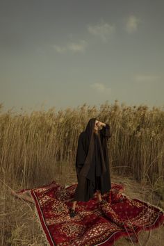 a woman standing on top of a rug in a field