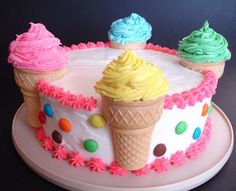 three ice cream cones on top of a cake with sprinkles and polka dots