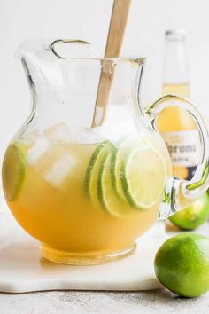 a pitcher filled with lemonade and limes