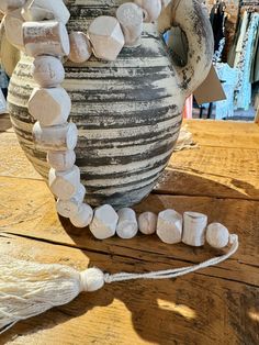 a vase with white rocks on it sitting on a wooden table next to other items