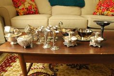 an assortment of silverware on a table in front of a couch