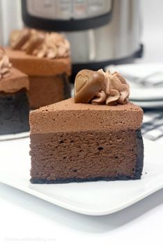 a piece of chocolate cake on a plate with an instant pressure cooker in the background