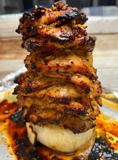 a stack of food sitting on top of a metal pan covered in sauce and meat