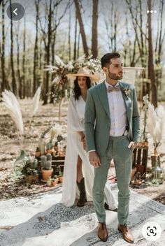 a man in a suit and tie standing next to a woman wearing a white dress