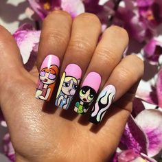 someone is holding up their nails with cartoon nail art on them and flowers in the background