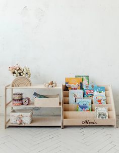 two wooden shelves with books and magazines on them, one shelf is open to show children's books