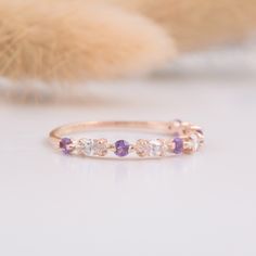 a pink and white diamond ring sitting on top of a table next to a stuffed animal