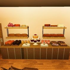 an assortment of pastries and desserts on display in a room with wood flooring